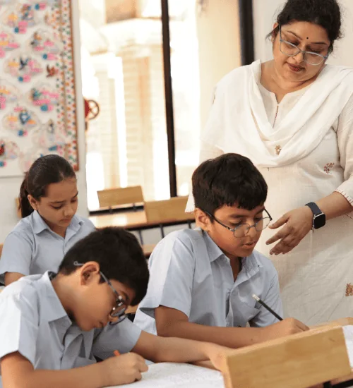 Teacher guiding students during classroom learning at Nalanda School Vadodara